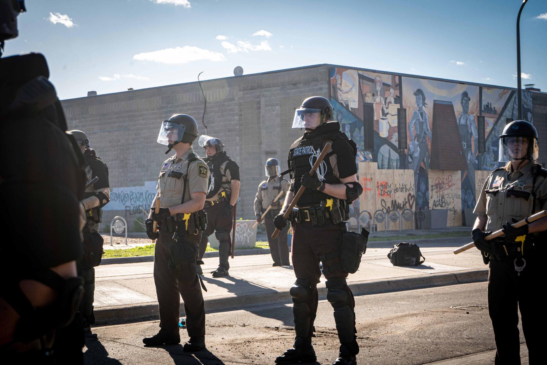 Police officers standing guard towards George Floyd protestors in minneapolis riot