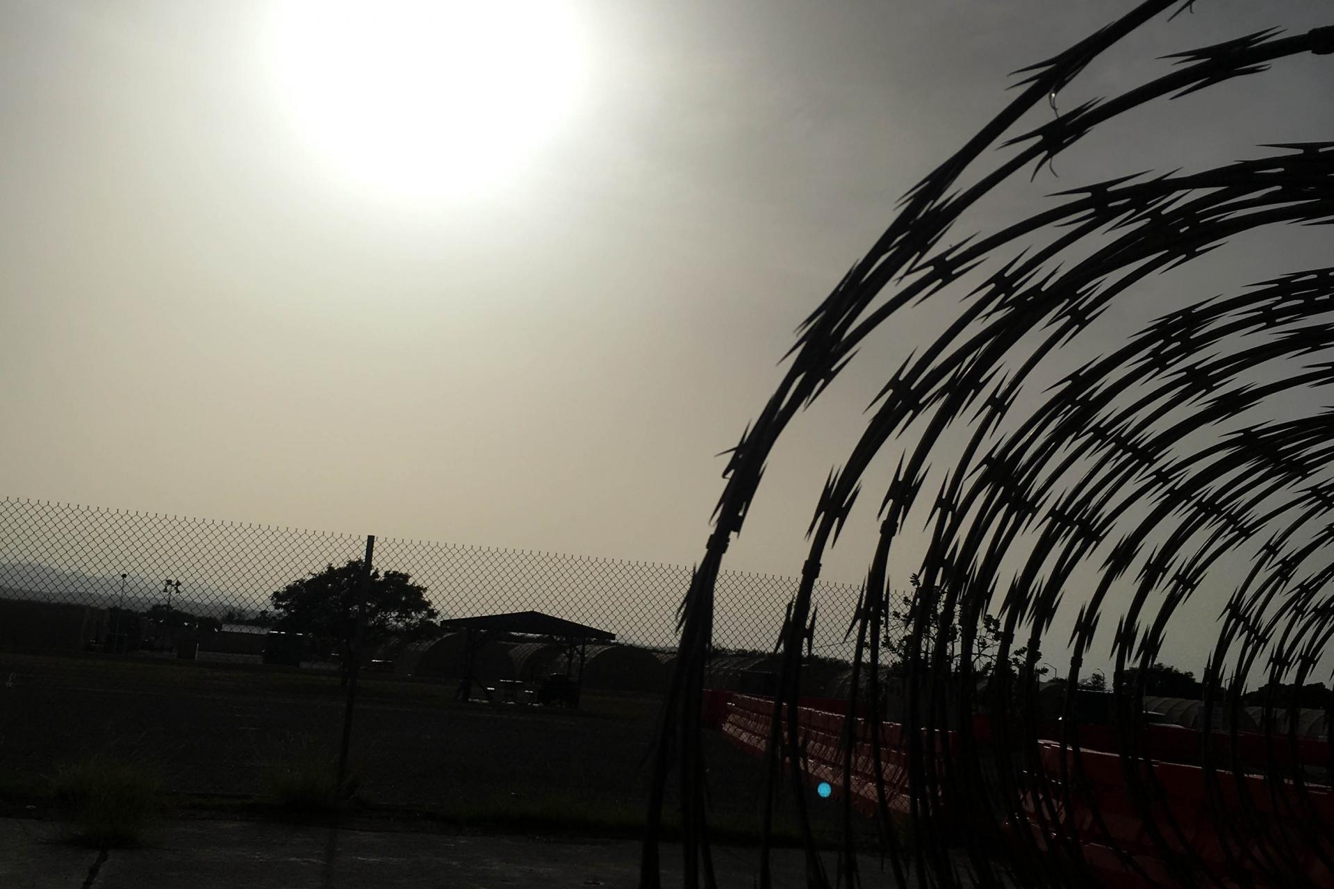 sun over razor wire fence