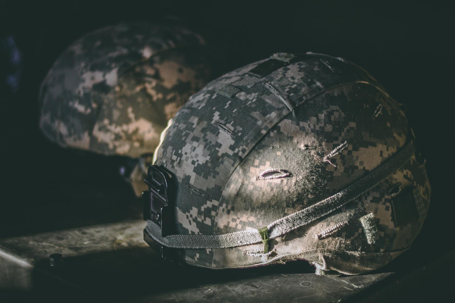 gray and brown camouflage nutshell helmet on a table