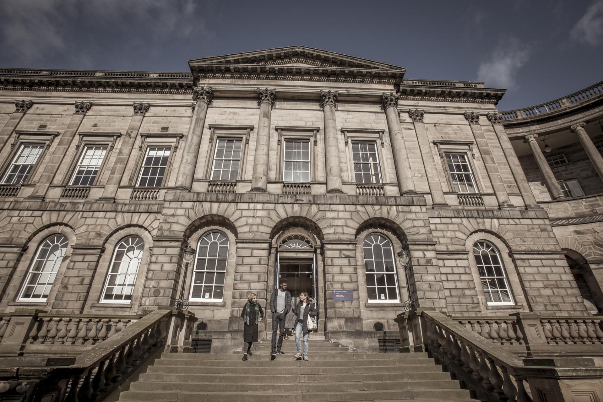 People walking down Old College steps