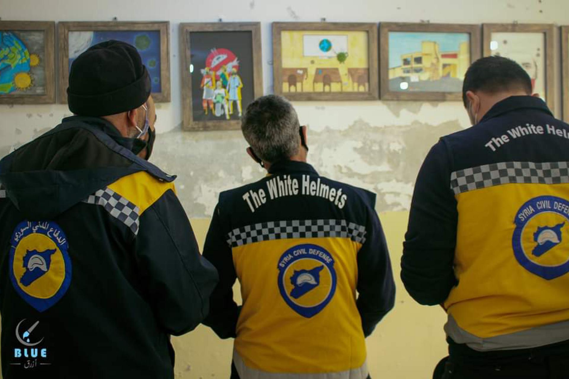 White Helmets in Syria looking at art