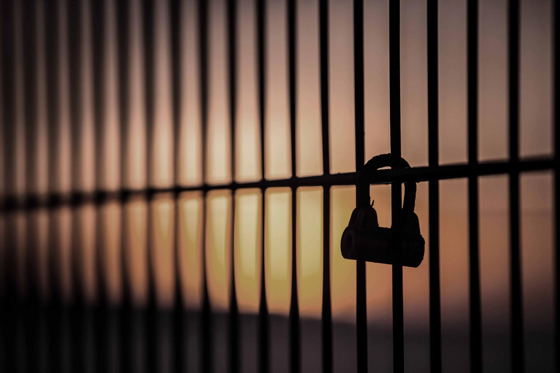 silhouette of padlock on fence