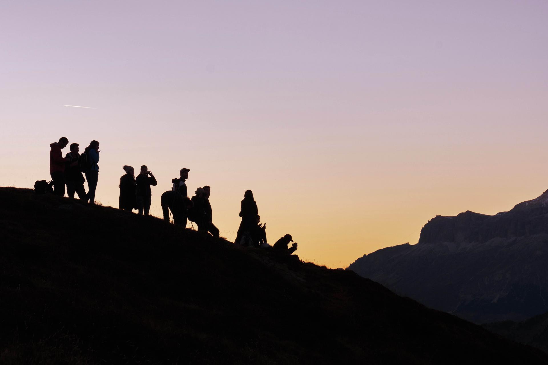 Silhouette of people on mountain with sky in background