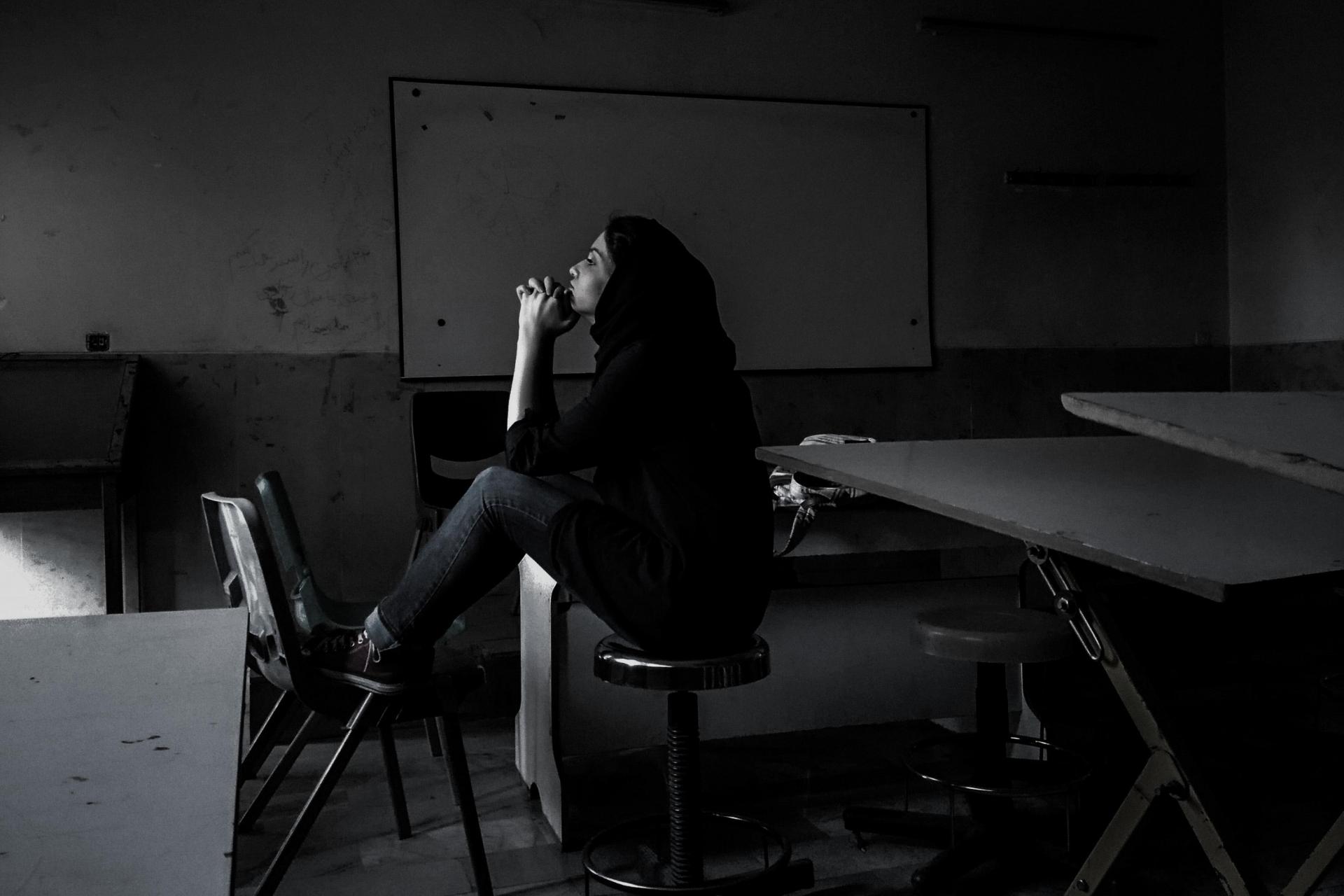 Woman sitting in darkened room