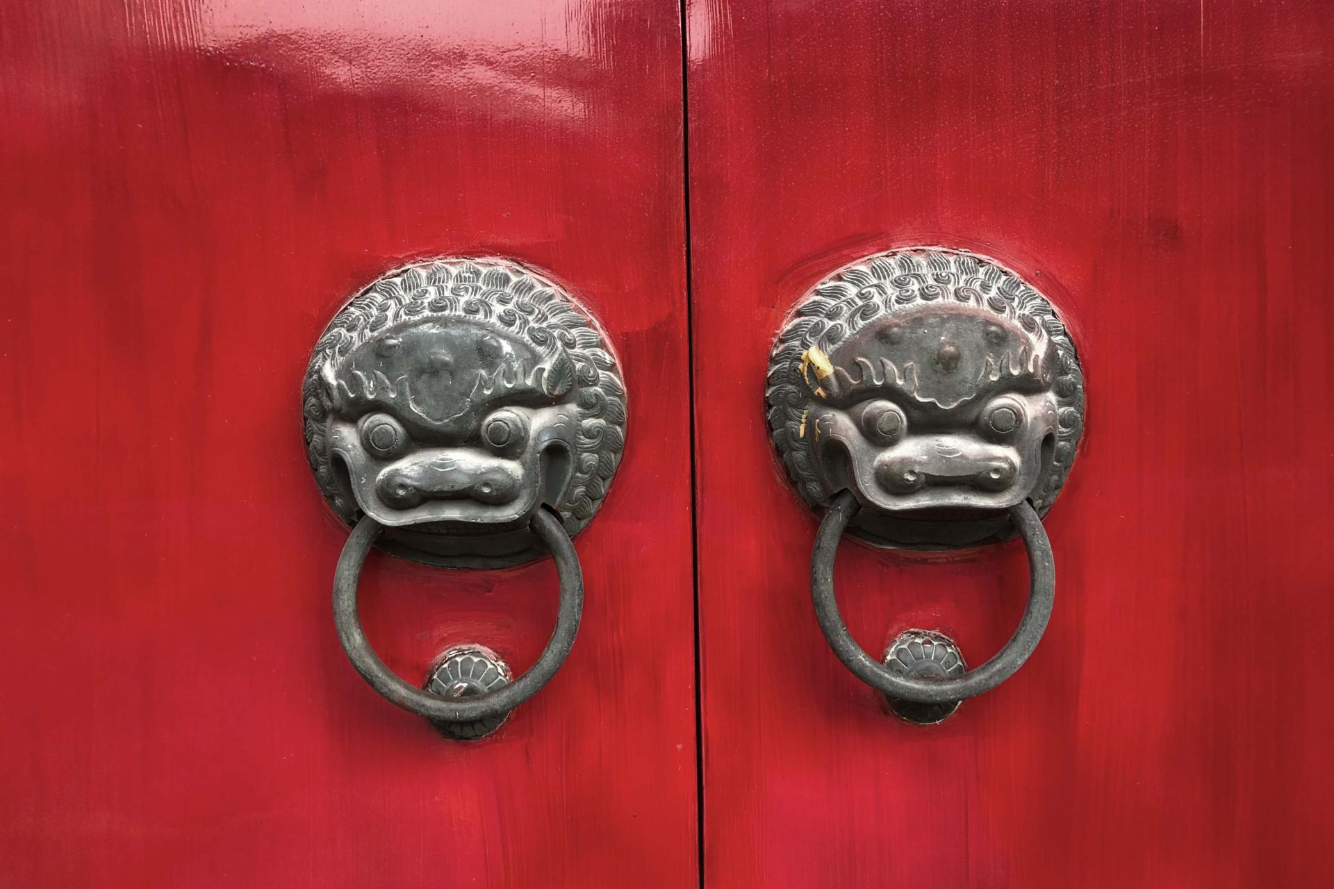 Grey door knobs on red door