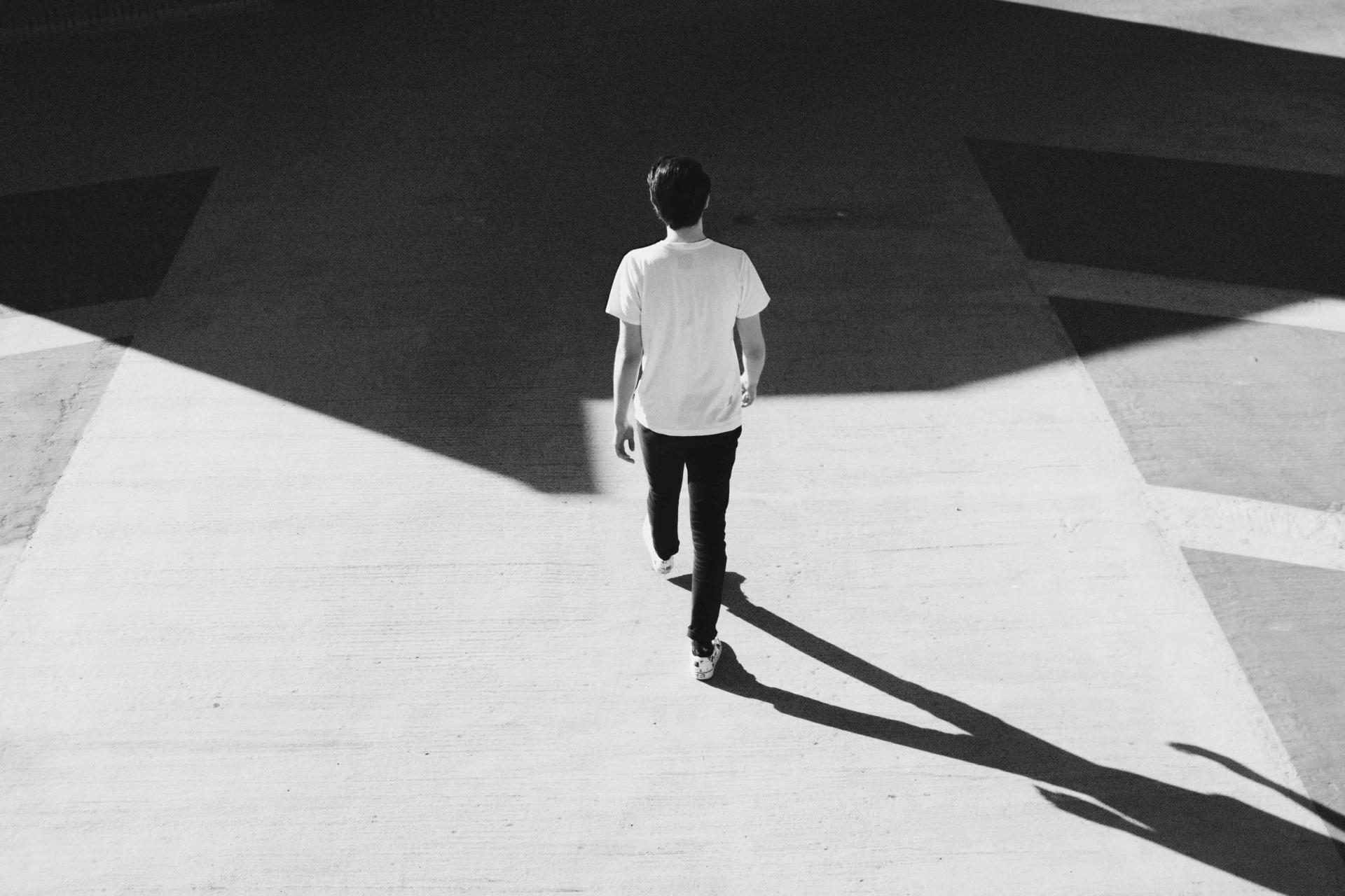 mank walking away on concrete road