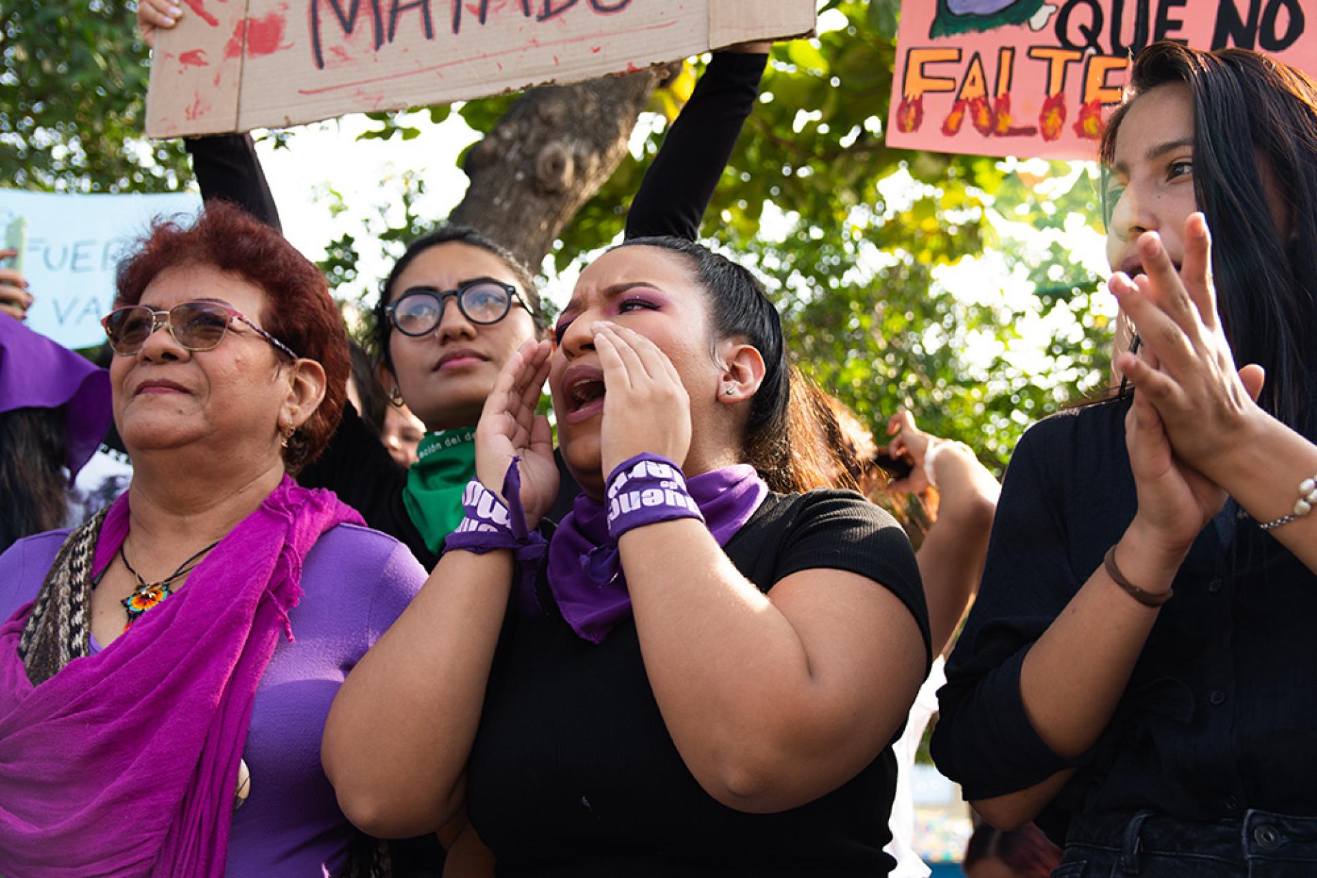 women at a protest holding signs and shouting