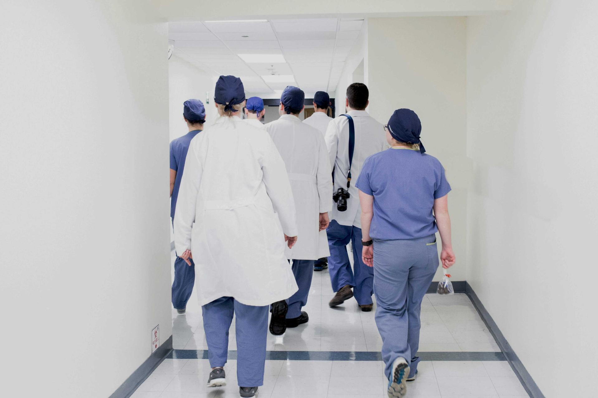a group of doctors with their backs to the camera walking away