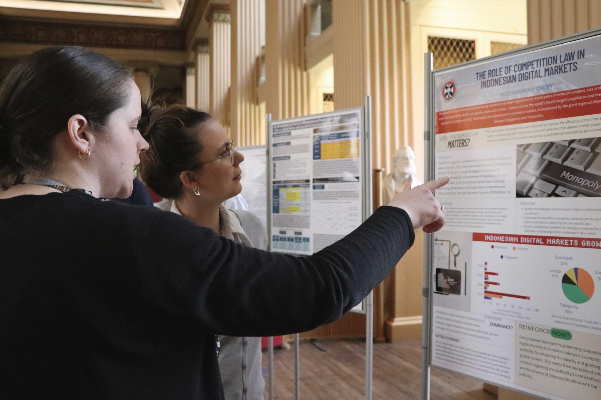 two people looking at a research poster