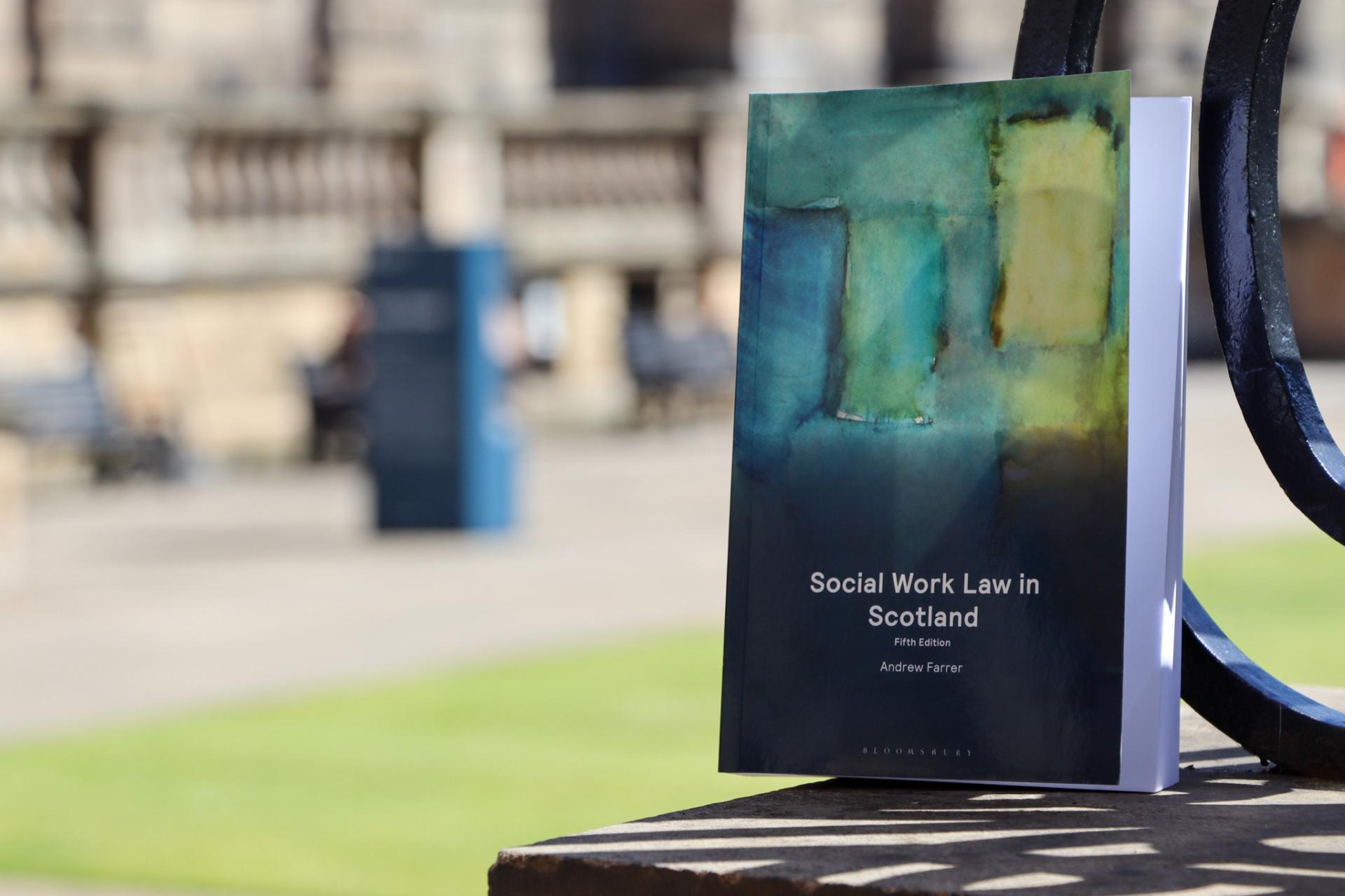 Social Work Law in Scotland book on stone pillar with Old College quad blurry in the background