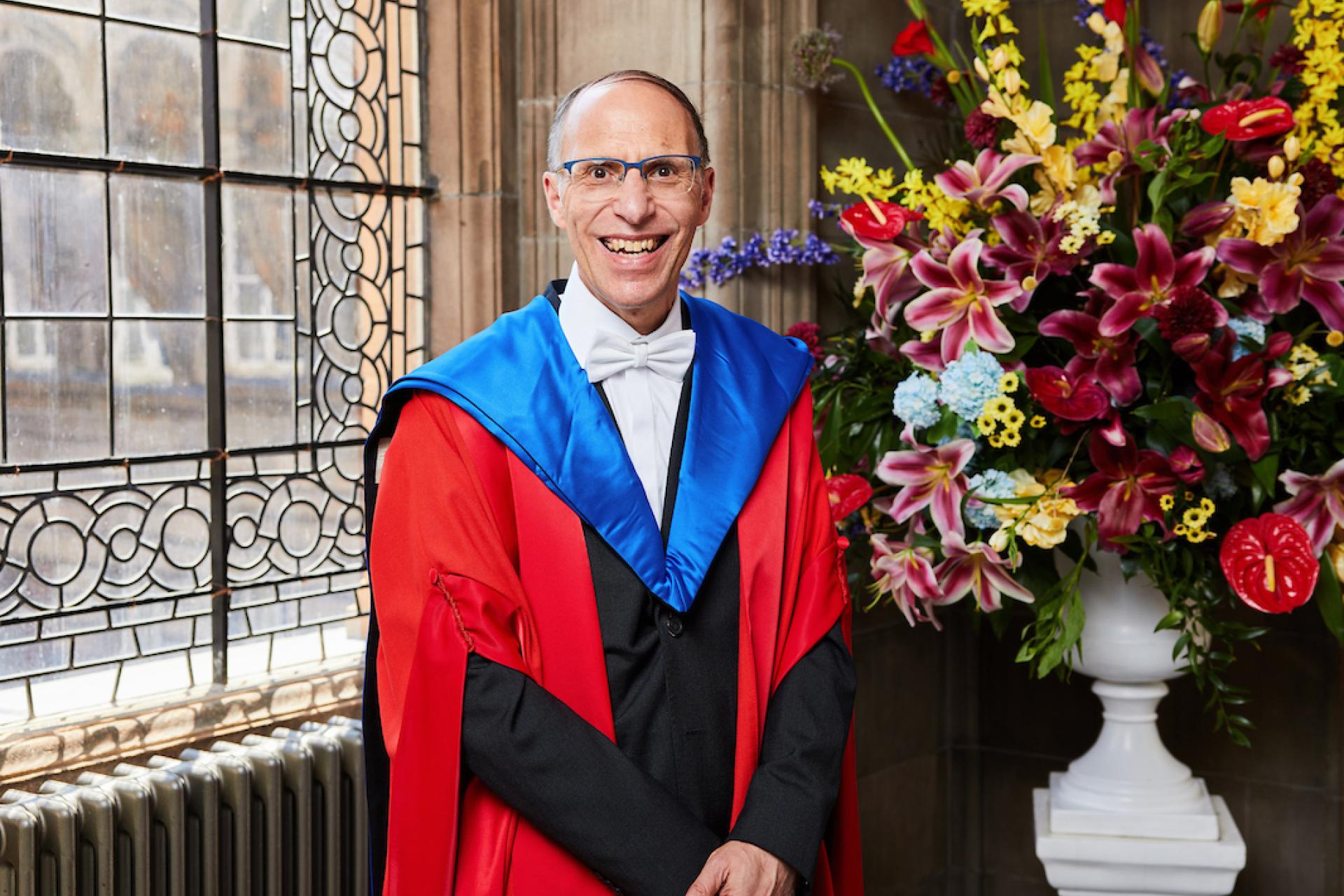 Professor Jean-Louis Halpérin standing in front of a window next to a large vase of flowers